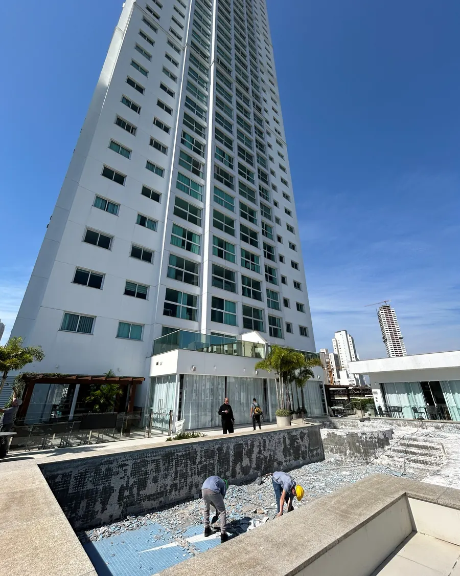 Colaboradores na manutenção da piscina, ao pé da torre entregue